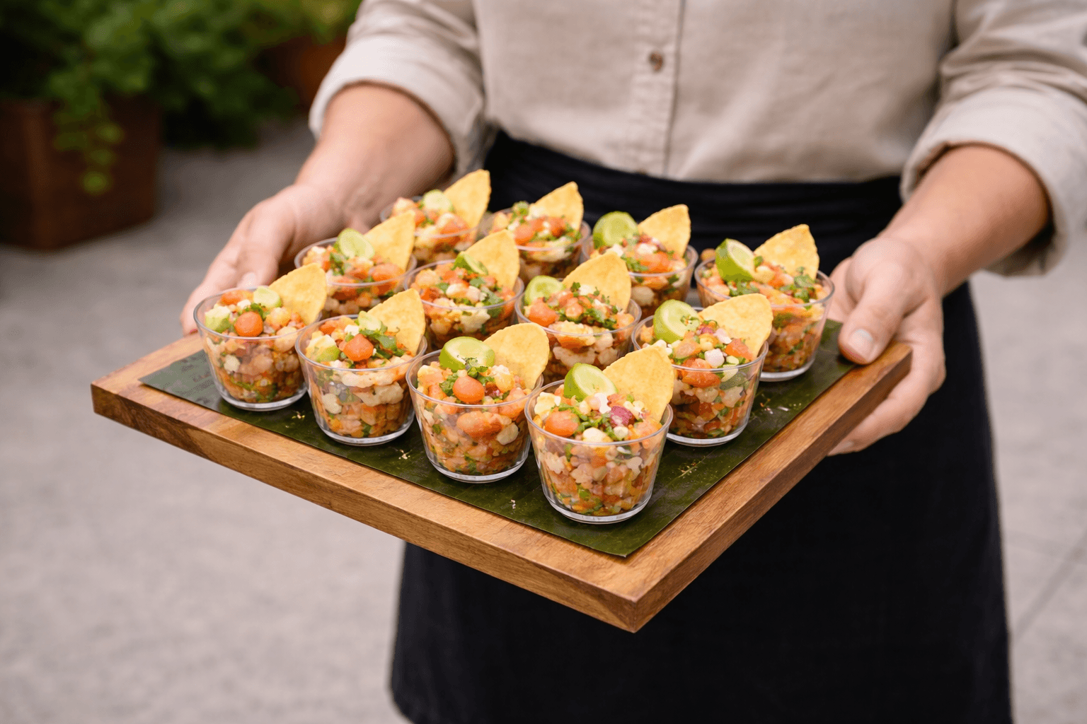 Individual ceviche cups on a wooden service tray